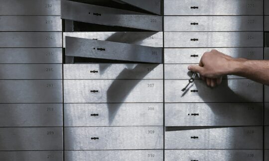 Hand holding keys in front of a metal locker